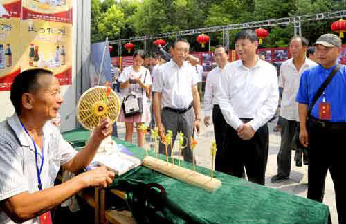 余學友察看“中國農加工洽談會”非物質文化遺產展展區(qū)