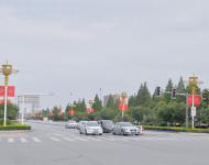 駐馬店市開源大道，道路兩旁清一色的紅旗在迎風(fēng)飄揚(yáng)。所有紅旗都是在燈桿的一側(cè)逆時(shí)針旋轉(zhuǎn)90°豎著懸掛，鮮艷的國(guó)旗整齊地朝向一側(cè)，非常壯觀。