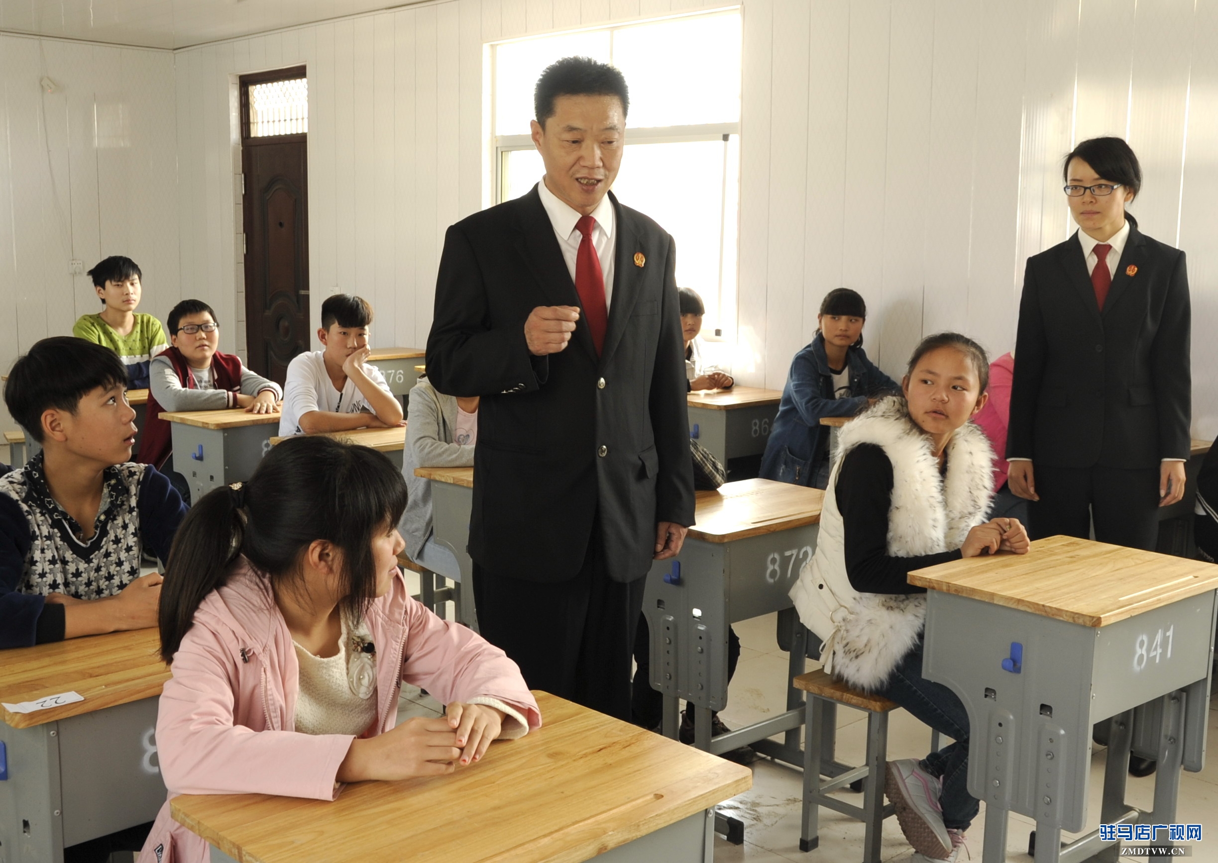 【04】泌陽(yáng)縣人民法院少年家事綜合審判庭的杜偉法官，正在向“旁聽(tīng)席”上的初中學(xué)生們講解法律知識(shí) (1).jpg
