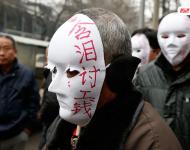 近幾年，由于經(jīng)濟增速下行，中西部地區(qū)和中小城市成為當前討薪矛盾多發(fā)地區(qū)。一邊是國家和地方維護打工者權(quán)益的法律法規(guī)不斷出臺，另一邊則是“年年干活年年欠，年年討薪年年難”。不少打工者不得已只好采取行為藝術(shù)等手段以博取關(guān)注。圖為2015年2月2日，西安市尚德路陜西省水利廳的門前，七八位頭戴著白色面具者站在凜凜寒風中，面具上寫著：“含淚討工錢” “無顏見父母”等標語。據(jù)了解，這幾個人是70名農(nóng)民工的代表，他們之前在武功縣干的工程被欠款156萬元。誰知，包工頭不但電話打不通，以前的家也搬了，根本找不到人，多次找到水