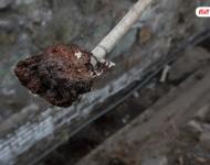 在遷安市中化煤化工有限責(zé)任公司的圍墻外是污水排放溝，溝里的泥成為紅褐色。