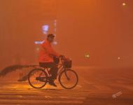 2017年1月4日早晨，一名環(huán)衛(wèi)工人在大霧中的安徽阜陽街頭騎行。盧啟建/視覺中國