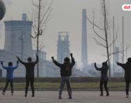 圖為耗資13億建成的邯鄲武安市體育館外，本地的不少中年婦女，每天會(huì)在固定時(shí)間來(lái)到這里：她們背對(duì)體育館，面向文安鋼鐵廠，跳起了廣場(chǎng)舞。邯鄲武安市區(qū)有十幾個(gè)鋼鐵廠、電廠、焦化廠包圍，不管刮什么風(fēng)，城區(qū)污染都很嚴(yán)重。視覺中國(guó)