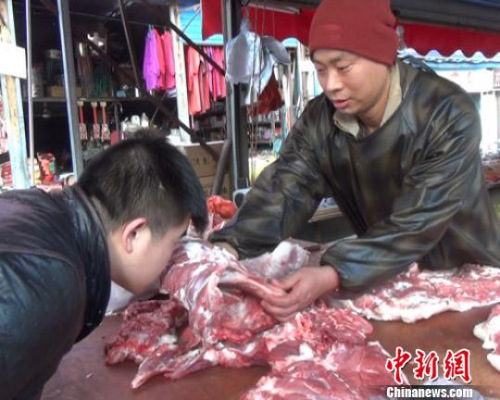 資料圖：一位賣(mài)羊肉的攤販正在教顧客從肉質(zhì)、色澤、氣味等方面識(shí)別瘦肉精羊肉 闞力 攝