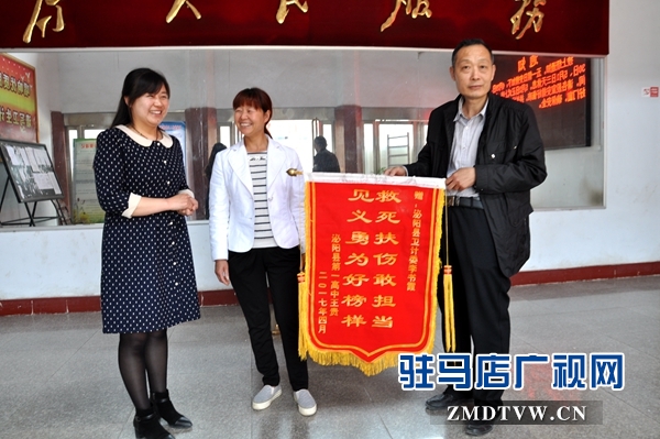 （圖二、縣衛(wèi)計委辦公室主任接過錦旗連聲說好?。?jpg