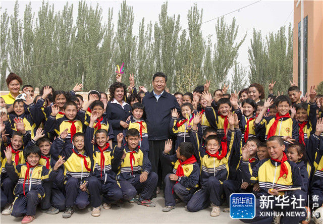  ↑2014年4月28日，習近平在新疆疏附縣托克扎克鎮(zhèn)中心小學同師生們合影。記者 謝環(huán)馳 攝 