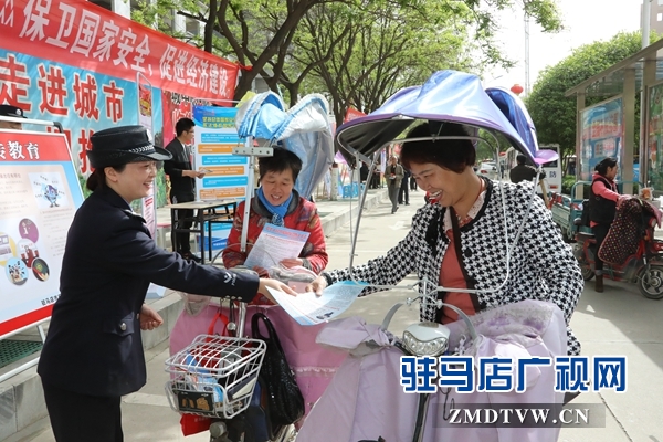 圖為民警向過(guò)往群眾發(fā)放宣傳頁(yè).JPG
