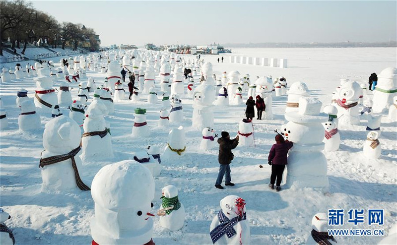 1月2日，市民、游客在雪人群中游玩觀賞（無(wú)人機(jī)拍攝）。2019個(gè)各式各樣的雪人，近日在冰城哈爾濱市的松花江畔亮相，引來(lái)眾多市民游客游玩觀賞。新華社記者 王建威 攝