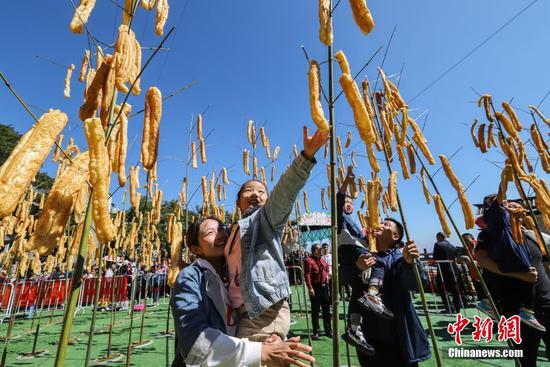 竹竿上“長(zhǎng)”油條，洛陽(yáng)民眾“摘”油條慶豐收